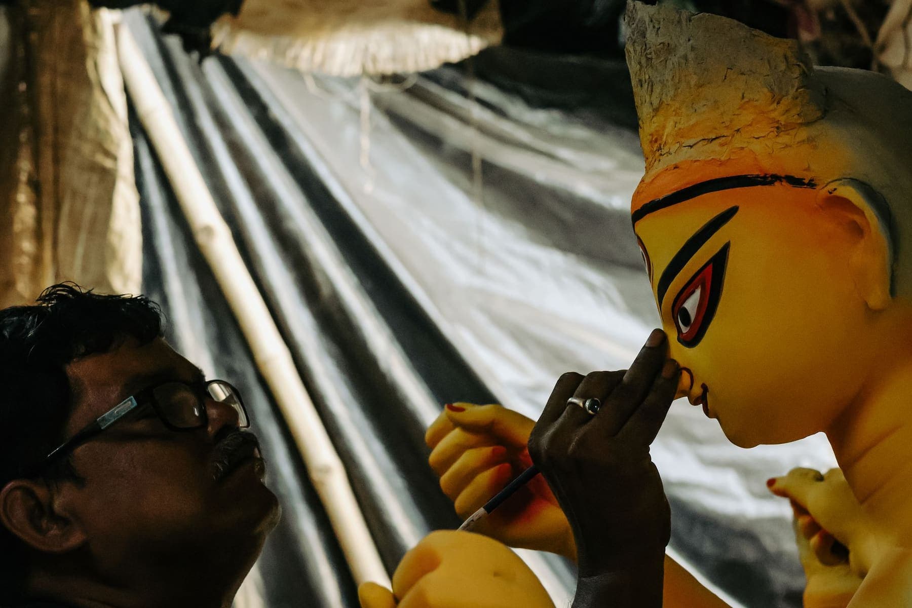 An artisan in Kumartuli paints the eyes of a clay Durga idol