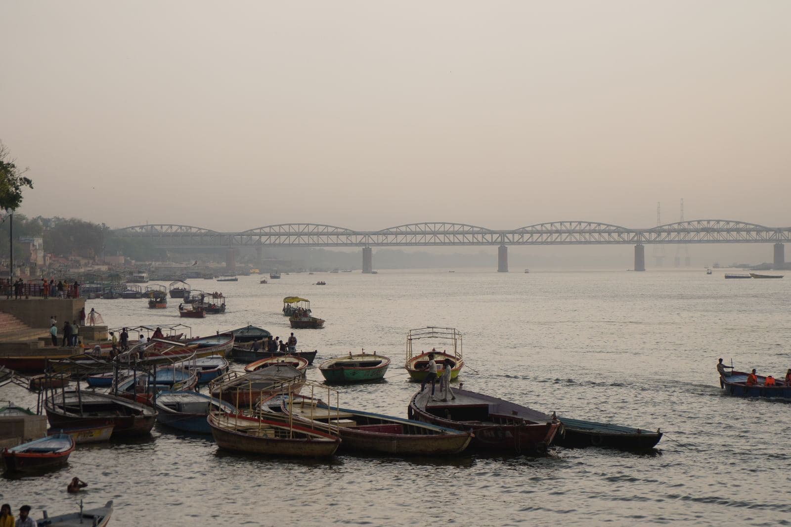 Morning haze over moored boats on the Ganga at Varanasi, with the Malviya bridge in the distance